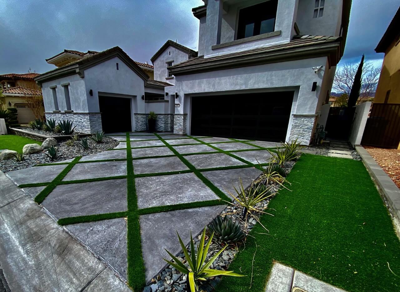 A driveway with grass and concrete in the middle of it.