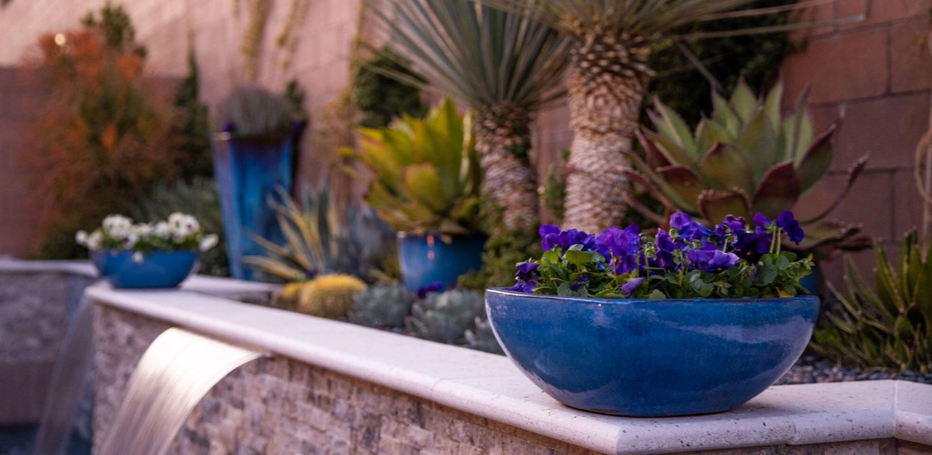 A blue bowl of flowers on the ledge