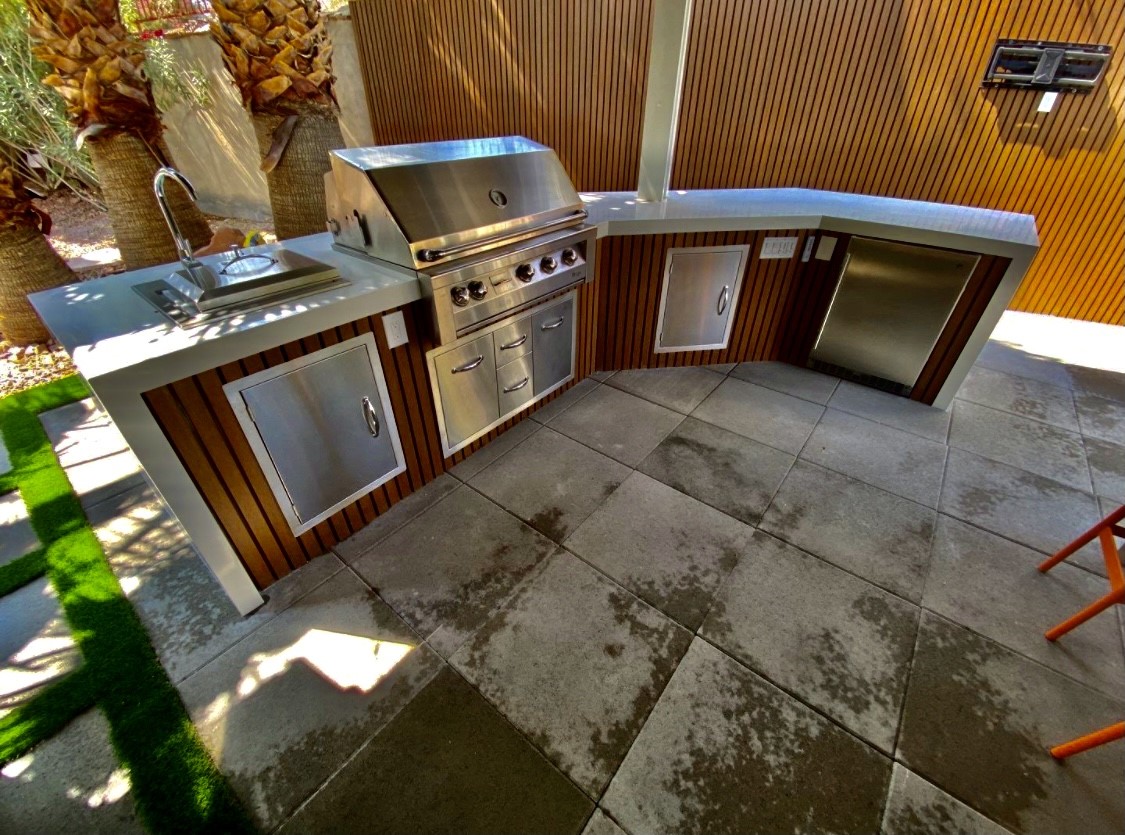 A large outdoor kitchen with stainless steel appliances.