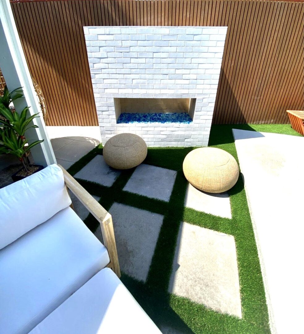 A patio with a fire place and grass.