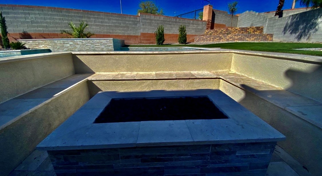 A large concrete pool with a black tile bottom.