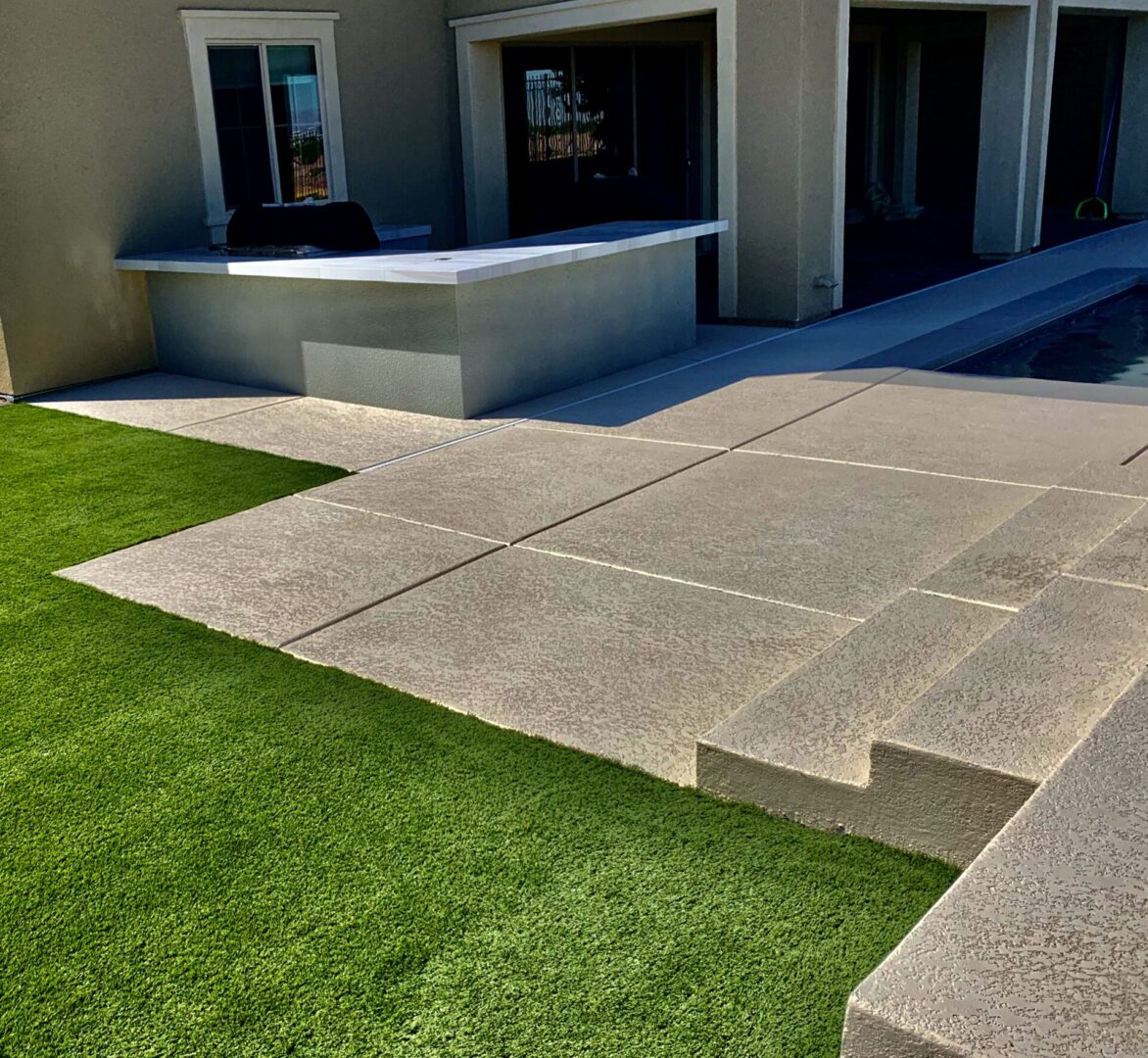 A concrete patio with steps leading to the garage.