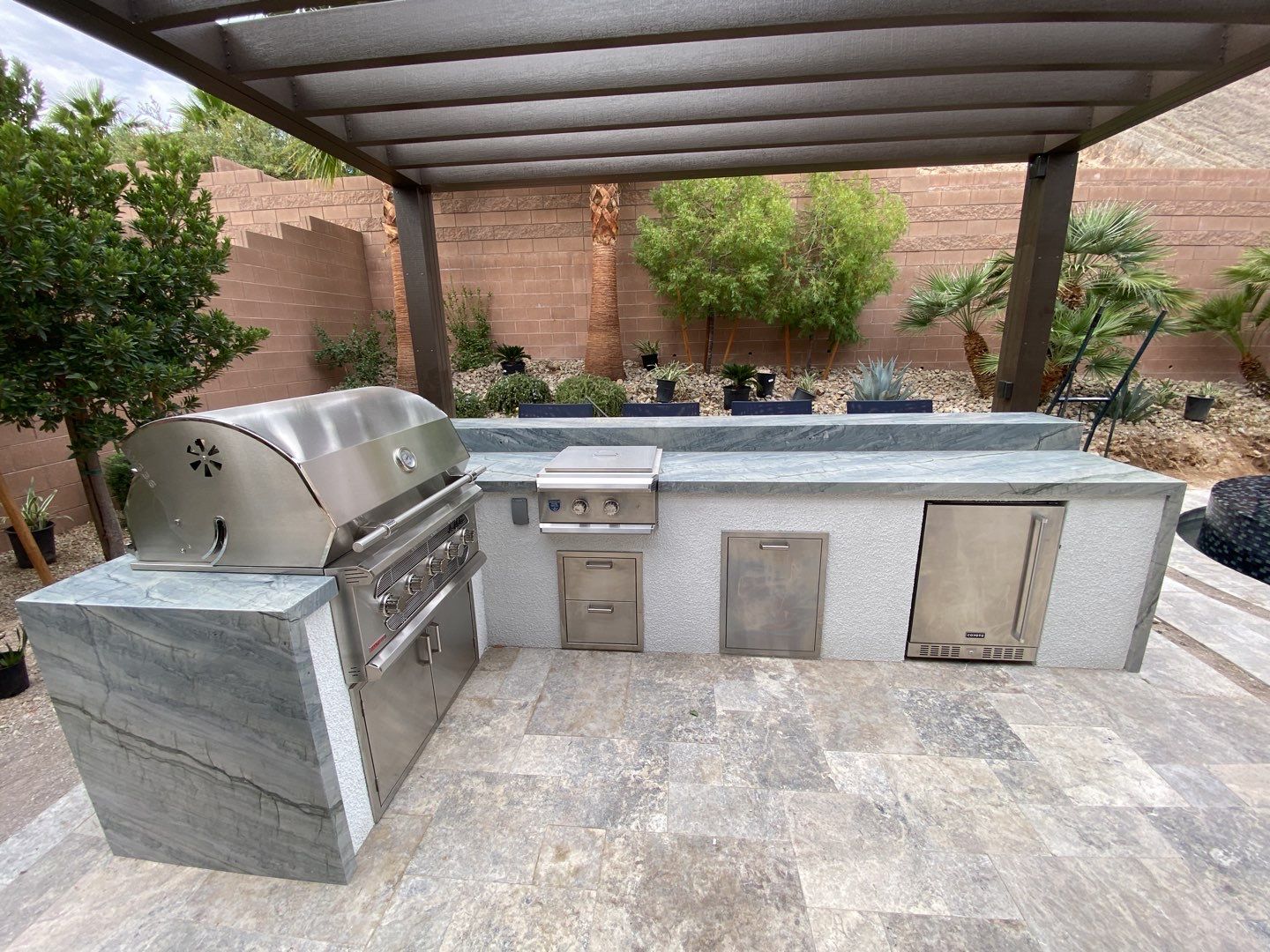 A bbq grill and sink in an outdoor kitchen.