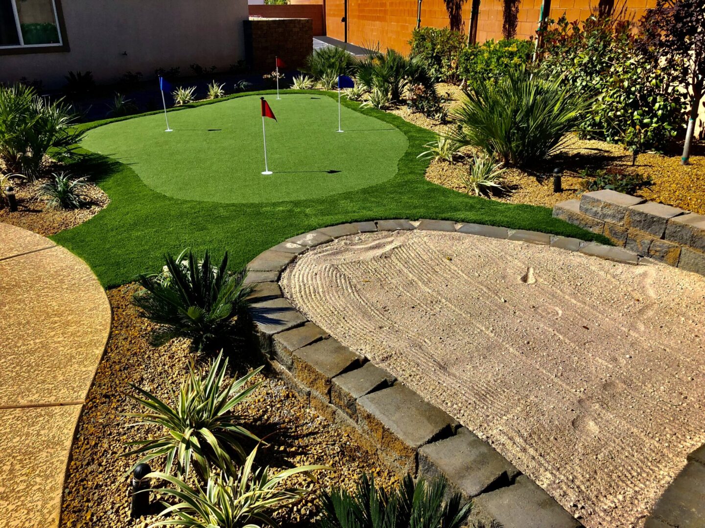 A backyard with a putting green and a golf course.