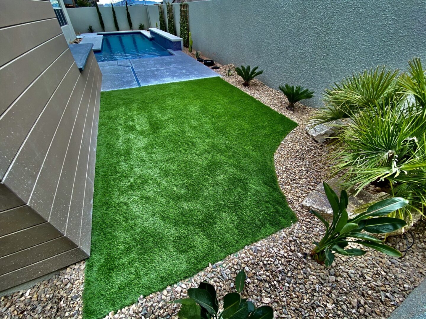 A backyard with a pool and grass