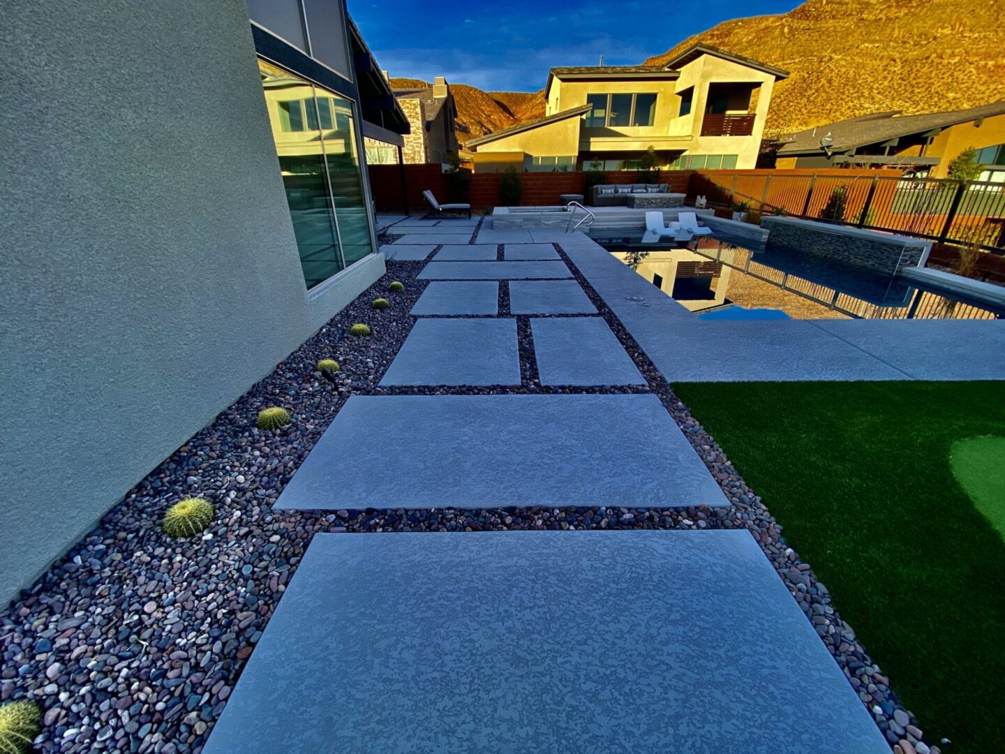 A view of a backyard with grass and concrete.