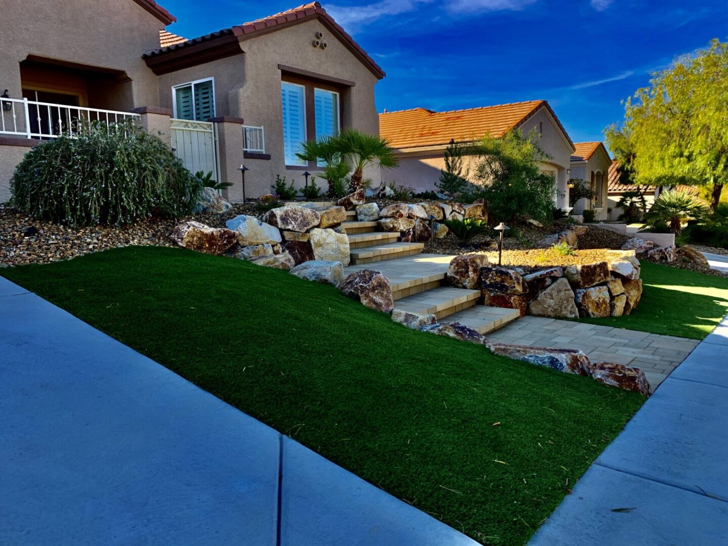 A yard with grass and rocks in the background.