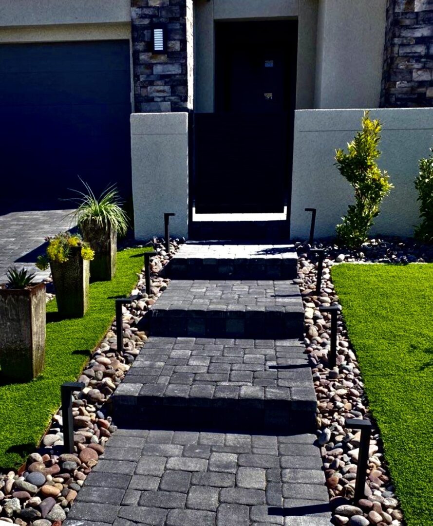 A walkway with steps and rocks leading to the front door.