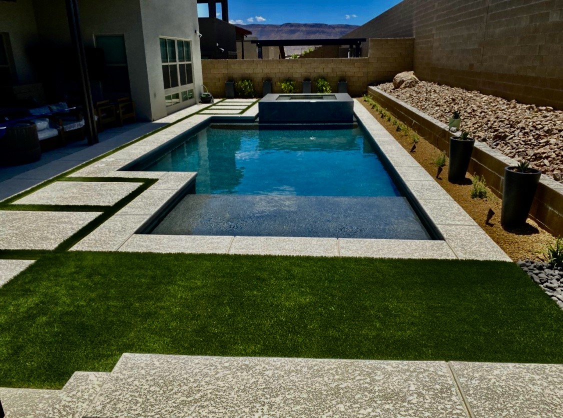 A pool with grass and rocks around it