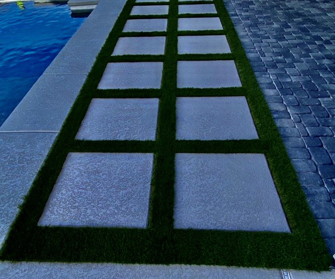 A walkway with grass between two concrete blocks.