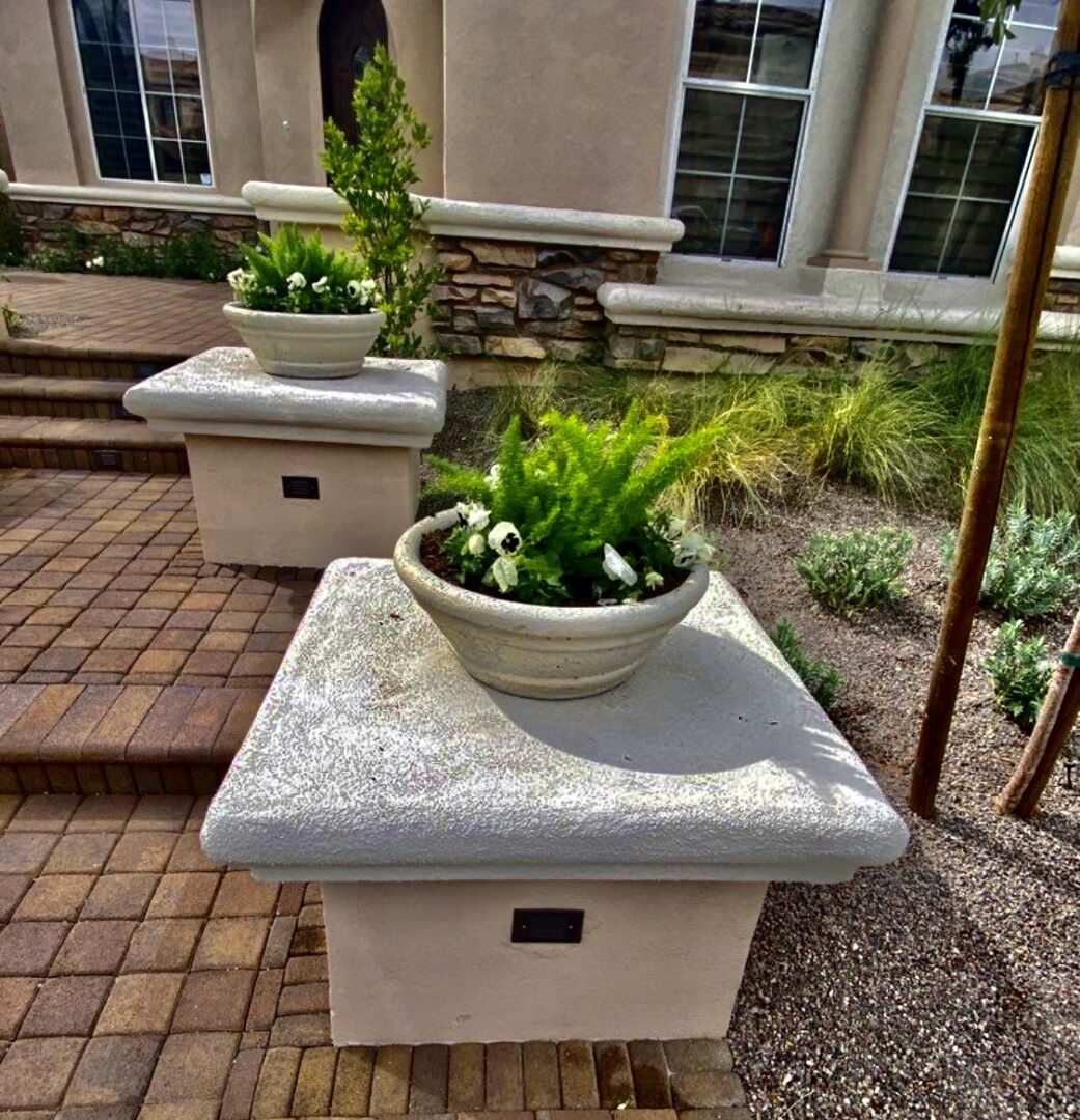 A planter sitting on top of a cement table.