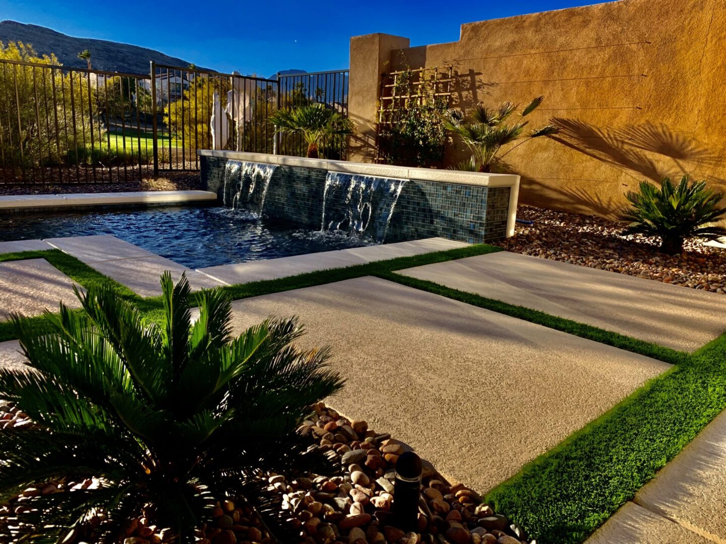 A backyard with a pool and water features