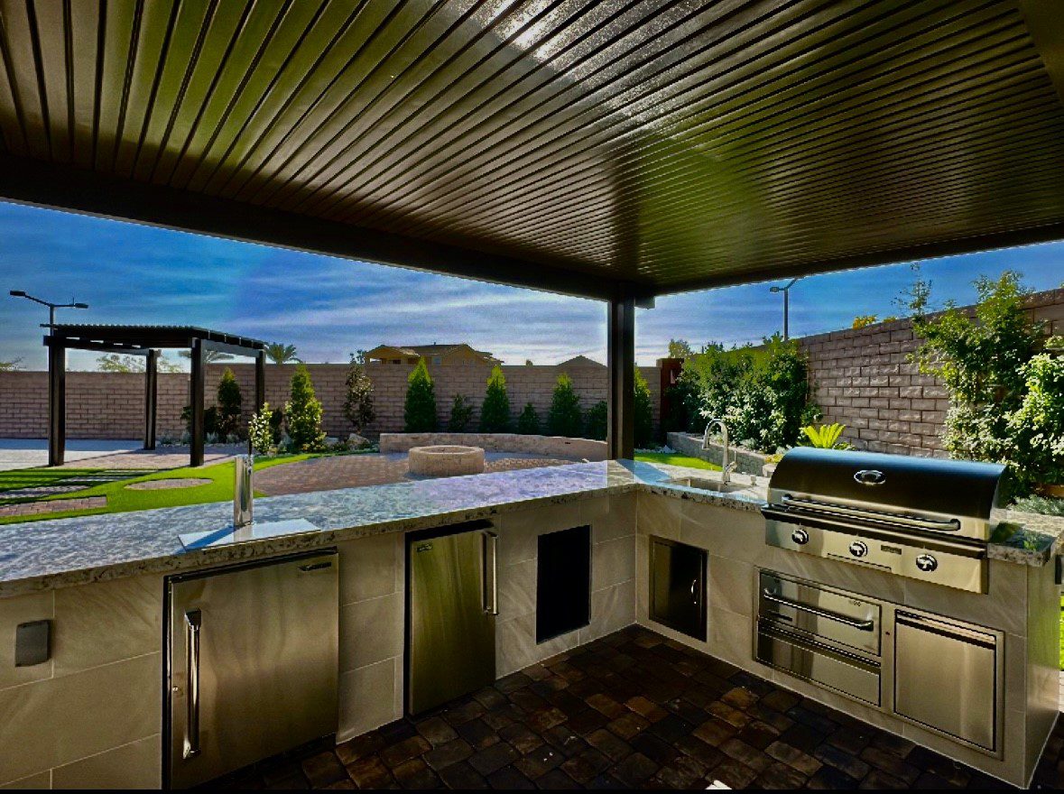 A large outdoor kitchen with an oven and grill.