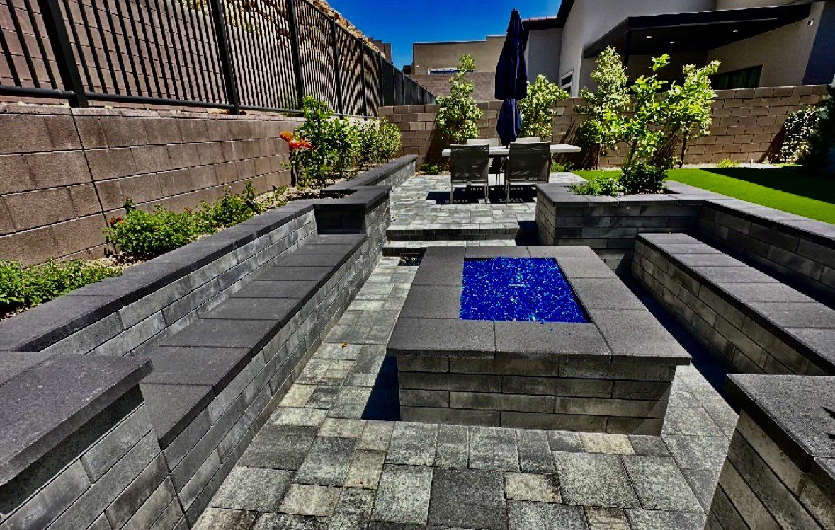 A patio with a fire pit and water feature.