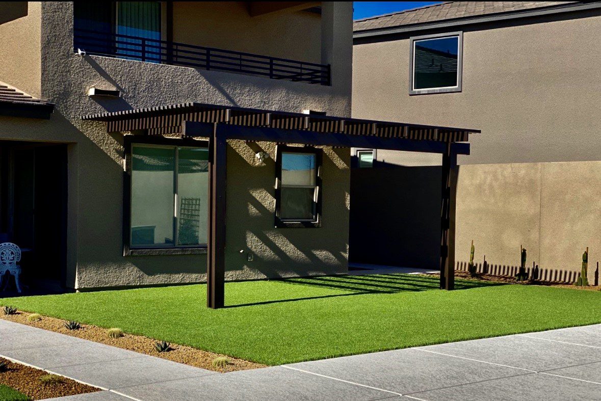 A patio with grass and a building